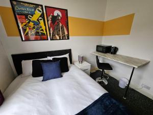 a bedroom with a bed and a desk and posters at Cannon Hill Shared House in Birmingham