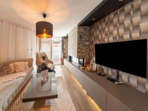 a living room with a large flat screen tv on a wall at Magnificent home with jacuzzi in La Calamine