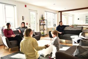 een gezin dat een videospel speelt in een woonkamer bij Le Partage Lodge: Destination plein air et sociale in Val-Morin