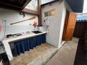 a kitchen with a counter with a blue curtain at German Home Tobias in Bahía de la Academia