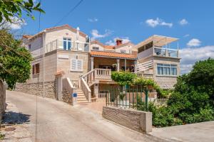 a large house on a street in front at Apartments by the sea Sumartin, Brac - 2952 in Sumartin