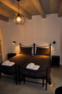 ein Schlafzimmer mit einem Bett mit zwei Handtüchern darauf in der Unterkunft Bramante Suites Urbino in Urbino
