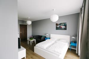 sypialnia z białym łóżkiem i salonem w obiekcie RENTTNER Apartamenty w Warszawie