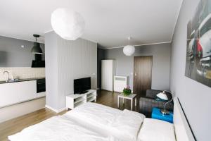 sypialnia z białym łóżkiem i kuchnią w obiekcie RENTTNER Apartamenty w Warszawie