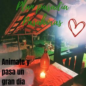 una botella de vino sentada en una mesa con una vela en Cabaña en el Árbol La Calera, en La Calera