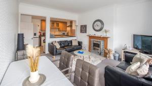 a living room with a couch and a table with a fireplace at Grosvenor Pad - Lovely 2-bed Flat - FREE ON STREET PARKING in Bath