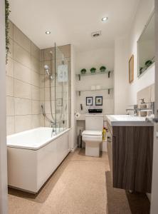 a bathroom with a tub and a toilet and a sink at Grosvenor Pad - Lovely 2-bed Flat - FREE ON STREET PARKING in Bath