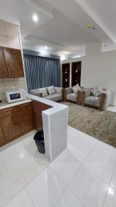 a large kitchen and living room with couches at شقق القارات السبع المخدومة in Medina