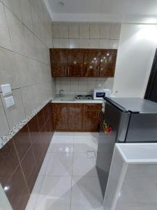 a small kitchen with a sink and a refrigerator at شقق القارات السبع المخدومة in Medina +10 photos