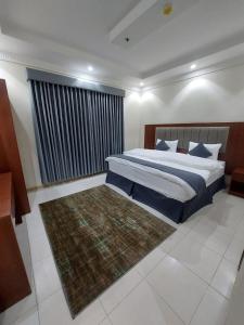 a bedroom with a large bed and a rug at شقق القارات السبع المخدومة in Medina