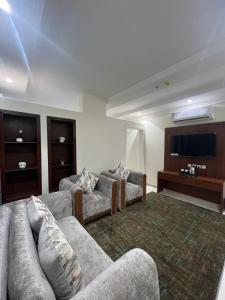a living room with couches and a flat screen tv at شقق القارات السبع المخدومة in Medina