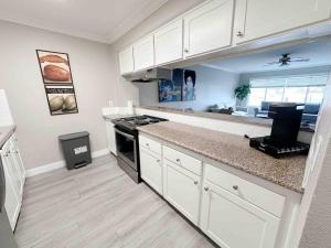 a kitchen with white cabinets and a counter top at Spacious South Bay Condo in Torrance