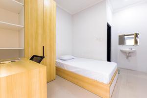 una piccola camera da letto con un letto e un lavandino di D Twinz House Syariah Redpartner a Tangerang Altre 28 foto