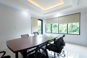 una sala da pranzo con tavolo e sedie in legno di D Twinz House Syariah Redpartner a Tangerang