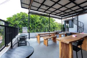 un patio con tavoli e panche in legno su un balcone. di D Twinz House Syariah Redpartner a Tangerang