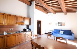 a kitchen with a table and a blue couch at 2 Bedroom Cozy Apartment In Gubbio in Gubbio