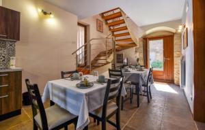 uma sala de jantar com mesas e uma escada em espiral em Beautiful Home In Chiaramonte Gulfi With Kitchen em Chiaramonte Gulfi