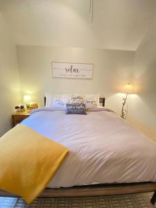 a bedroom with a large bed with white sheets at A Relaxation Station in Nashville