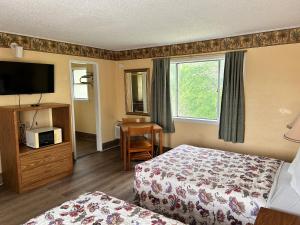 um quarto de hotel com duas camas e uma televisão em River forest inn em Belton