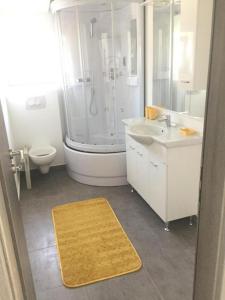 ein Badezimmer mit Dusche, Waschbecken und Toilette in der Unterkunft Apartments with a parking space Kastel Gomilica, Kastela - 22714 in Kaštela + 19 Fotos