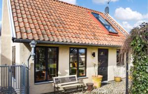 a house with an orange roof with a bench at Stunning Home In Ystad With Kitchen in Ystad