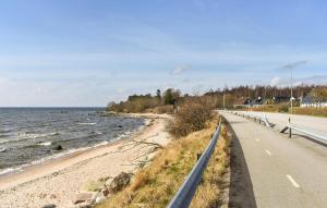 a road next to a beach next to the ocean at Stunning Home In Ystad With Kitchen in Ystad +9 photos