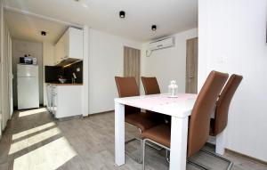 a dining room with a white table and chairs at Beautiful Home In Murter in Murter