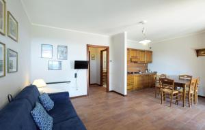 a living room with a blue couch and a kitchen at Stunning Apartment In Gubbio With Wifi in Gubbio
