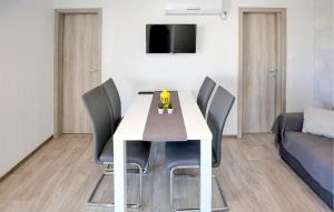 a dining room with a white table and chairs at Gorgeous Home In Murter in Murter