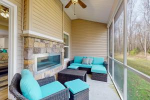 a screened porch with a couch and chairs and a tv at Millville by the Sea --- 36515 Calm Water Dr in Millville