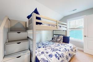 a bedroom with a bunk bed with a bedspread at Millville by the Sea --- 36515 Calm Water Dr in Millville