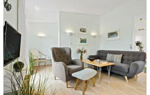 ein Wohnzimmer mit einer Couch und zwei Stühlen und einem Tisch in der Unterkunft Lovely Apartment In Nexø With Sauna in Neksø