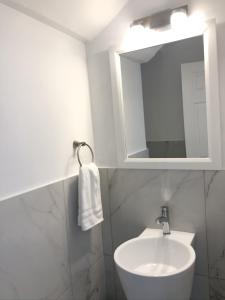 a white bathroom with a sink and a mirror at 101E Jolly Harbour in Jolly Harbour
