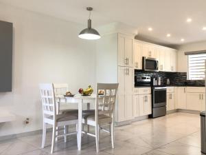 a kitchen with a table with chairs and a microwave at 101E Jolly Harbour in Jolly Harbour