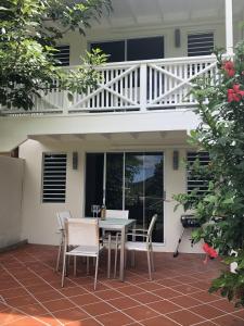 a patio with a table and chairs and a balcony at 101E Jolly Harbour in Jolly Harbour
