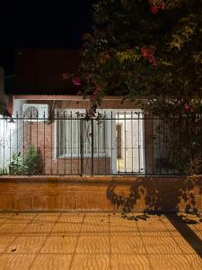een hek voor een huis met bloemen bij M&M’s House in Termas de Río Hondo