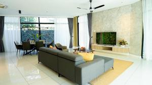 a living room with a couch and a dining room at Cenang Plaza Beach Hotel in Pantai Cenang