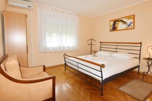 a bedroom with a bed and a chair at Family friendly house with a swimming pool Umag - 22775 in Umag