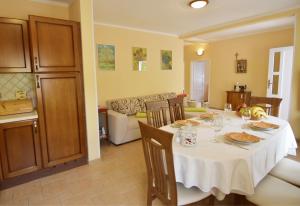 a dining room with a table and a living room at Family friendly house with a swimming pool Umag - 22775 in Umag