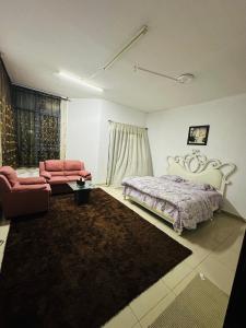 a living room with a bed and a couch at Tranquil Haven:King Bed, Ensuite, Master Bedroom in Ajman 