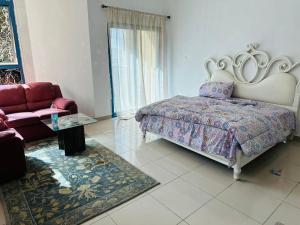 a bedroom with a large bed and a couch at Tranquil Haven:King Bed, Ensuite, Master Bedroom in Ajman 