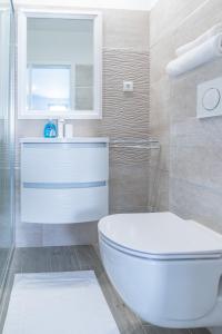een badkamer met een wit toilet en een spiegel bij Holiday house with a parking space Split - 22855 in Split +26 foto's