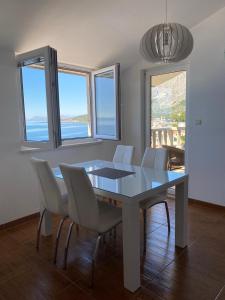 a dining room with a table and white chairs at Apartments by the sea Drasnice, Makarska - 22864 in Drasnice