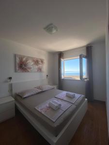 a bedroom with a large bed with a window at Apartments by the sea Drasnice, Makarska - 22864 in Drasnice +10 photos