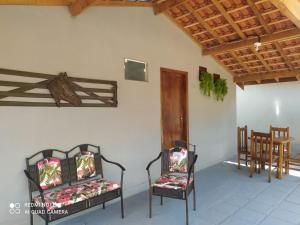 Habitación con 2 sillas, mesa y techo de madera. en Pousada irmãos Oliveira en Lindóia
