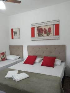 1 Schlafzimmer mit 2 Betten und roten Kissen in der Unterkunft Pousada irmãos Oliveira in Lindóia