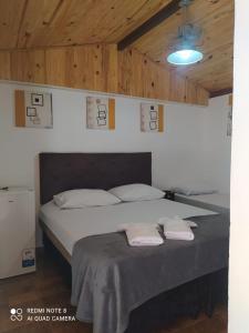 ein Schlafzimmer mit einem Bett mit zwei Handtüchern darauf in der Unterkunft Pousada irmãos Oliveira in Lindóia