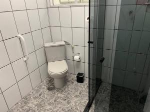uma casa de banho com um WC branco numa cabina em Cocal em São Vicente