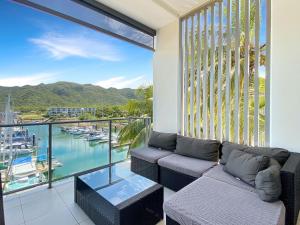a balcony with a couch and a view of a marina at Blue on Blue Penthouse Apartment 335 in Nelly Bay