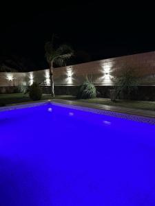 uma piscina azul à noite com luzes em Mi Sanagasta Querida em La Rioja